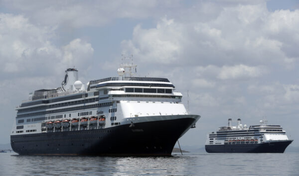 The Zaandam cruise ship, left, carrying some guests with flu-like symptoms, is anchored shortly after it arrived to the bay of Panama City