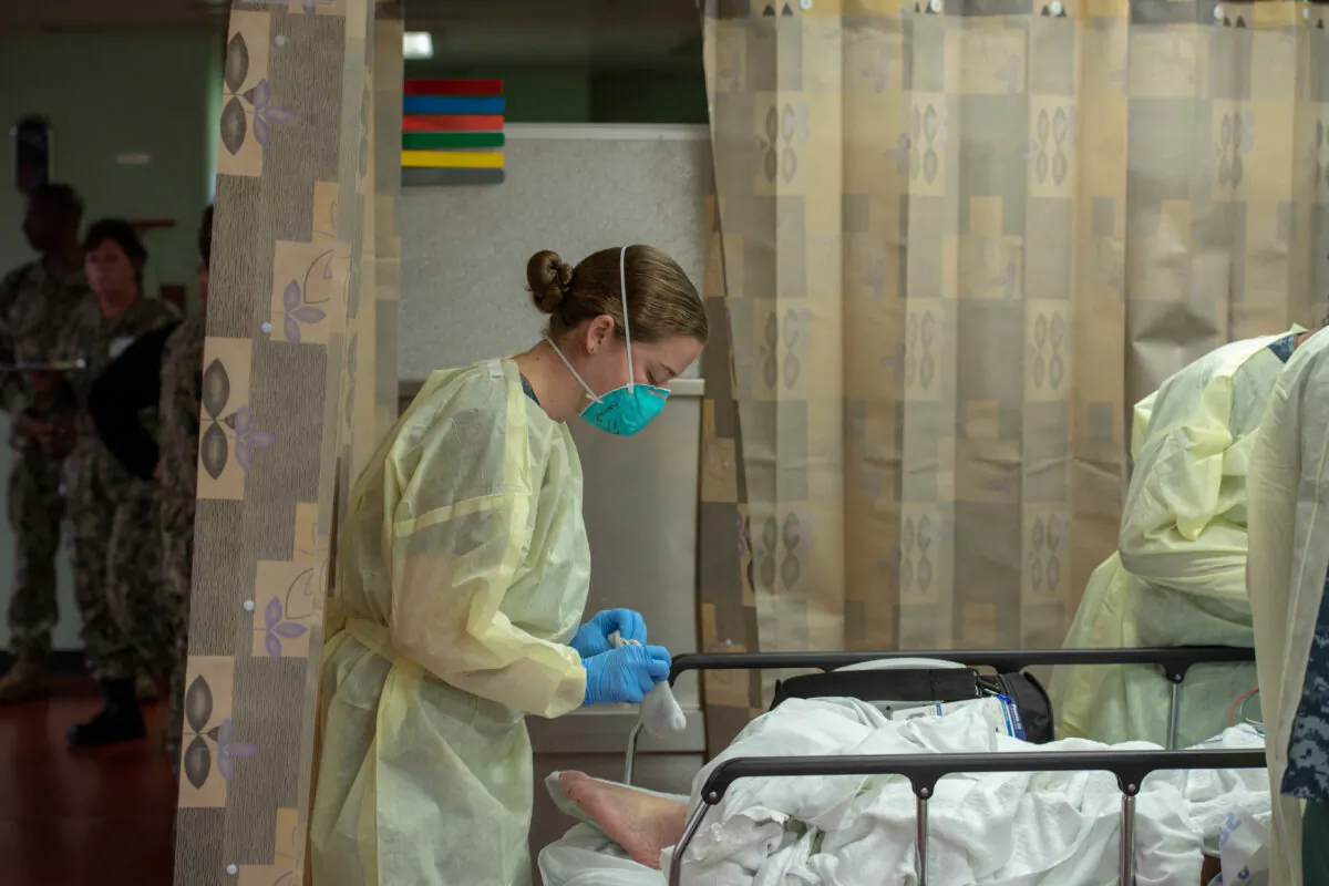 A sailor treats a patient aboard the hospital ship USNS Mercy, which was deployed to serve as a referral hospital for non-CCP virus patients currently admitted to shore-based hospitals, in Los Angeles, Calif., on March 29, 2020. (Mass Communication Specialist 2nd Class Erwin Jacob Miciano/U.S. Navy/Reuters)