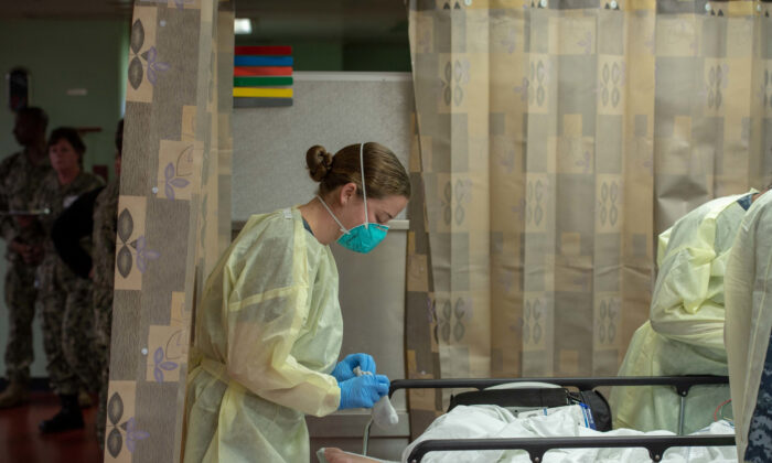 A sailor treats a patient aboard the hospital ship USNS Mercy, which was deployed to serve as a referral hospital for non-CCP virus patients currently admitted to shore-based hospitals, in Los Angeles, Calif., on March 29, 2020. (U.S. Navy/Mass Communication Specialist 2nd Class Erwin Jacob Miciano/Handout via Reuters)