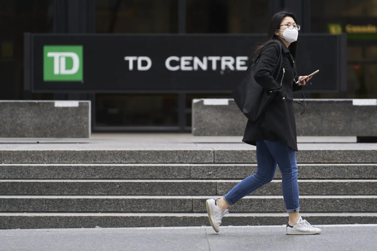 A woman in a mask walks in the financial district in Toronto, Ontario on March 24, 2020. (Geoff Robins/AFP via Getty Images)