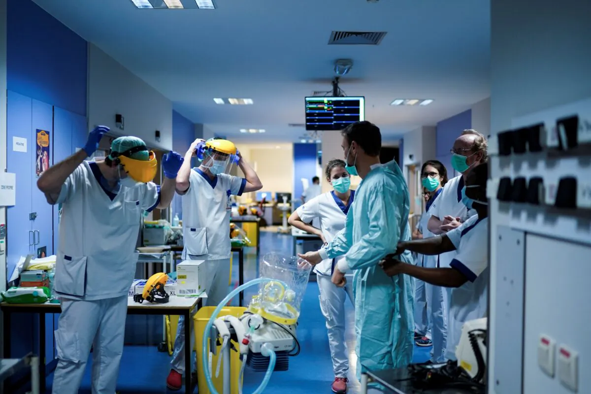 Medical workers put on their protective gears before working at the unit for coronavirus COVID-19 infected patients at the Erasme Hospital in Brussels on March 27, 2020. (Kenzo Tribouillard/AFP via Getty Images)