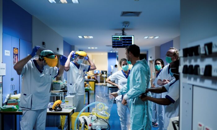 Medical workers put on their protective gears before working at the unit for coronavirus COVID-19 infected patients at the Erasme Hospital in Brussels on March 27, 2020. (Kenzo Tribouillard/AFP via Getty Images)