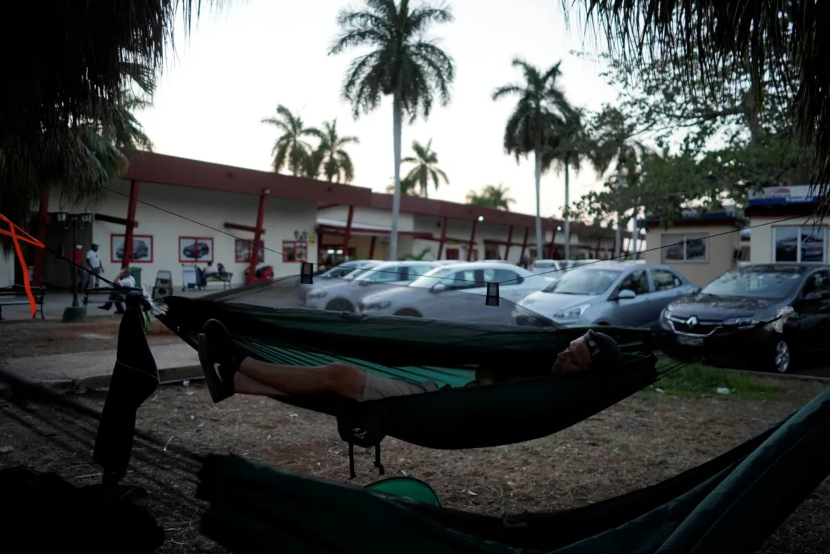 Tourist from Belgium Olivier Decamps takes a nap outside the Jose Marti International Airport after his flight was cancelled by the airline amid concerns about the spread of the CCP virus outbreak, in Havana, Cuba, on March 23, 2020. (Alexandre Meneghini/File/Reuters)