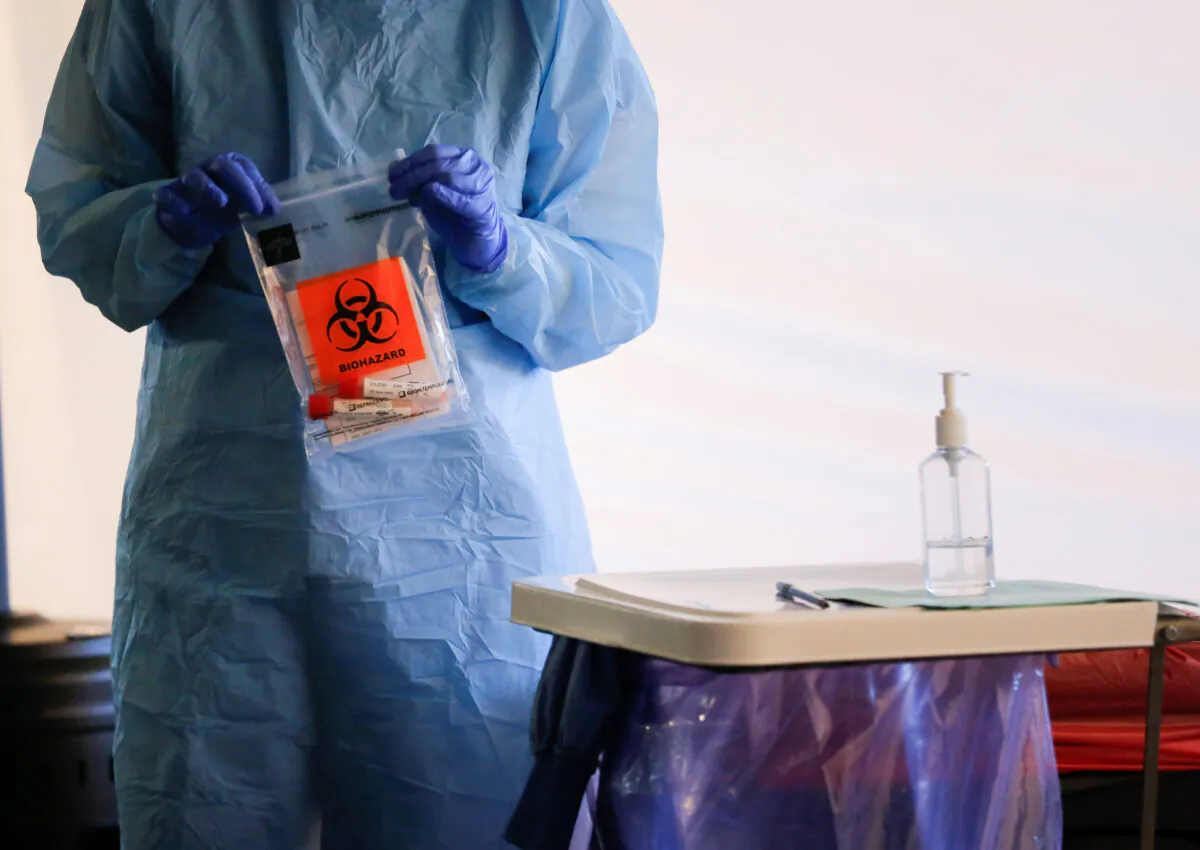 A nurse holds a completed test with patient samples at a drive-through testing site for the new CCP virus in Washington state in a March 9, 2020, file photograph. (Lindsey Wasson/Reuters)