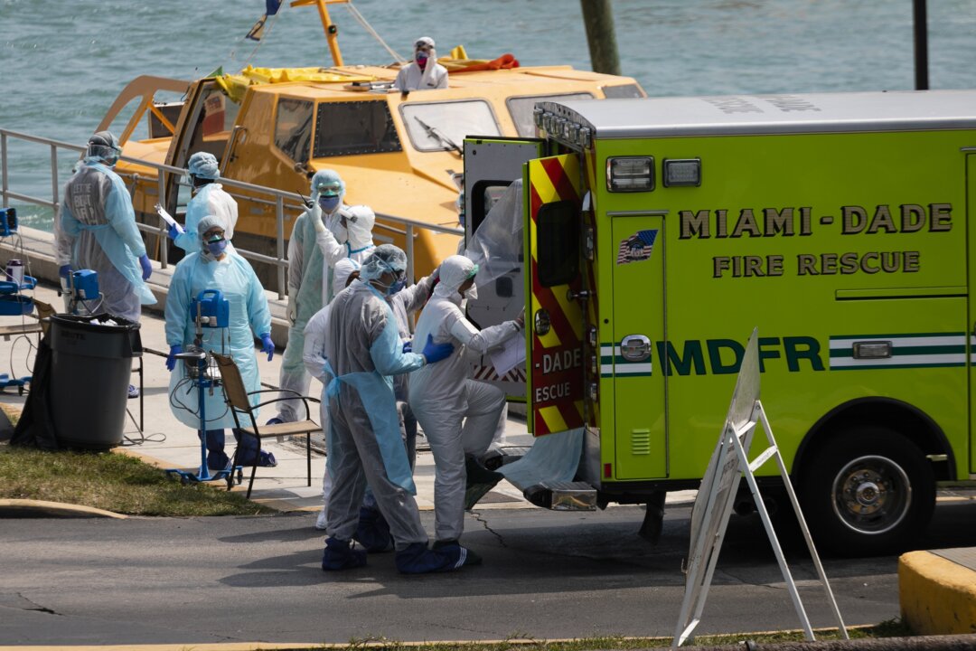 Medical staff transfer suspected CCP virus patients in an ambulance to a medical facility after they arrive at the United States Coast Guard Base in Miami Beach in Miami, Florida, on March 26, 2020. (Eva Marie Uzcategui/Getty Images)