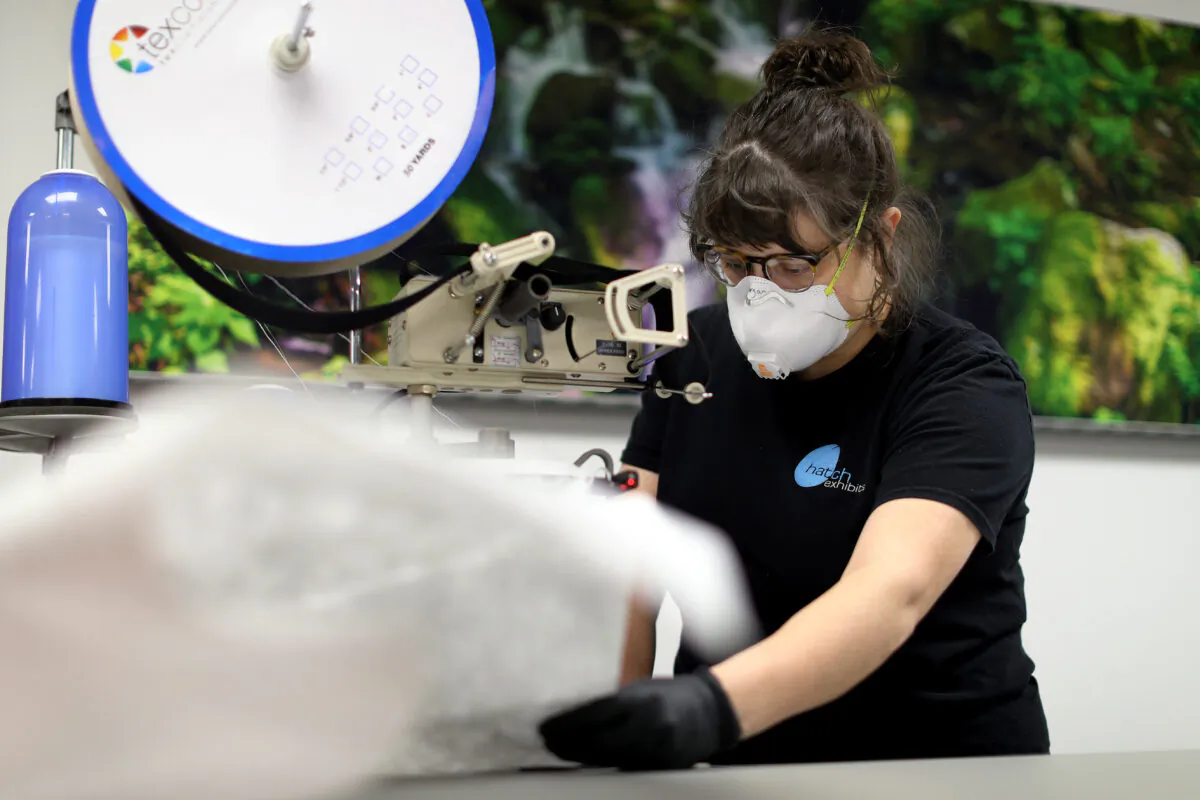 Hatch Exhibits fabricator and installer Morgan Frailey sews together medical gowns the company produces to protect people from the CCP virus, in Elkridge, Maryland, on March 31, 2020. (Chip Somodevilla/Getty Images)