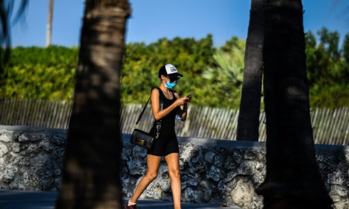 A woman wears a mask as she walks on Ocean Drive in South Beach, Florida, on March 31, 2020. (Chandan Khanna/AFP via Getty Images)