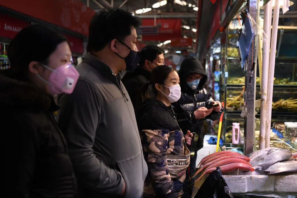 Local residents wear masks as they shop at a market in Beijing on Feb. 27, 2020. (Greg Baker/AFP via Getty Images)