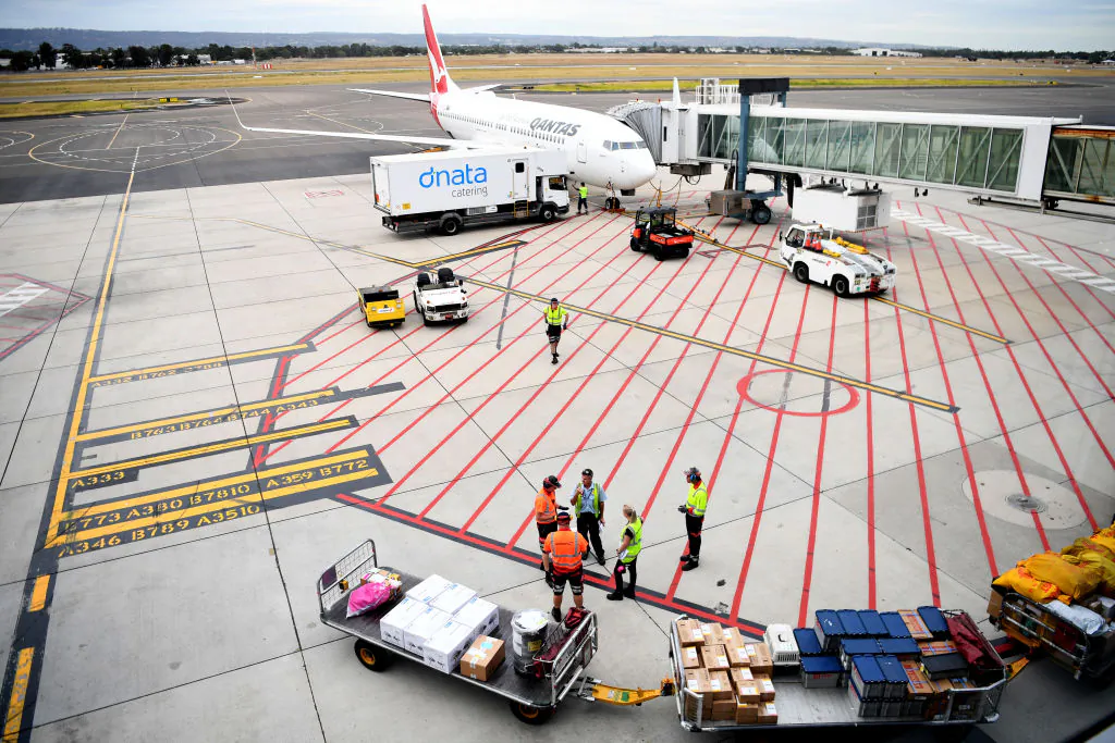 Baggage handers load a Qantas plane at Adelaide Airport in Adelaide, Australia on April 1, 2020. (Tracey Nearmy/Getty Images)