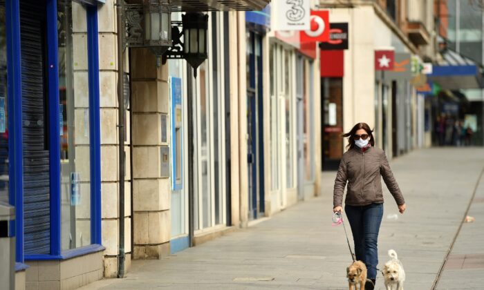 A member of the public walks her dogs down an empty high street in the city center in Exeter, England on April 2, 2020. (Dan Mullan/Getty Images)