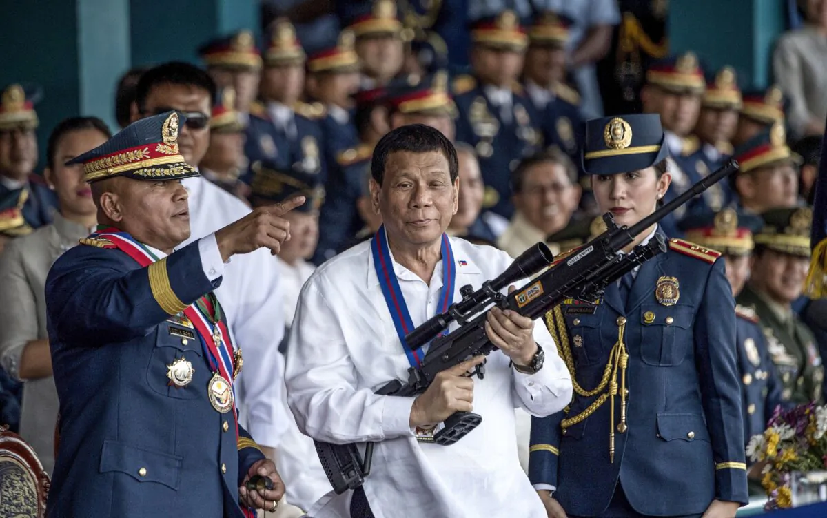 Philippine President Rodrigo Duterte holding a Galil sniper rifle with outgoing Philippine National Police (PNP) chief Ronald dela Rosa (L) during the change of command ceremony at Camp Crame in Manila on on April 19, 2018. (Noel Celis/AFP via Getty Images)