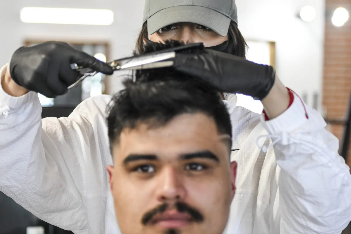 The Bar.Ber.Shop stylist Brenda Escobedo gives Alan Gomez a haircut in Greeley, Colo., on April 28, 2020. (Michael Ciaglo/Getty Images)