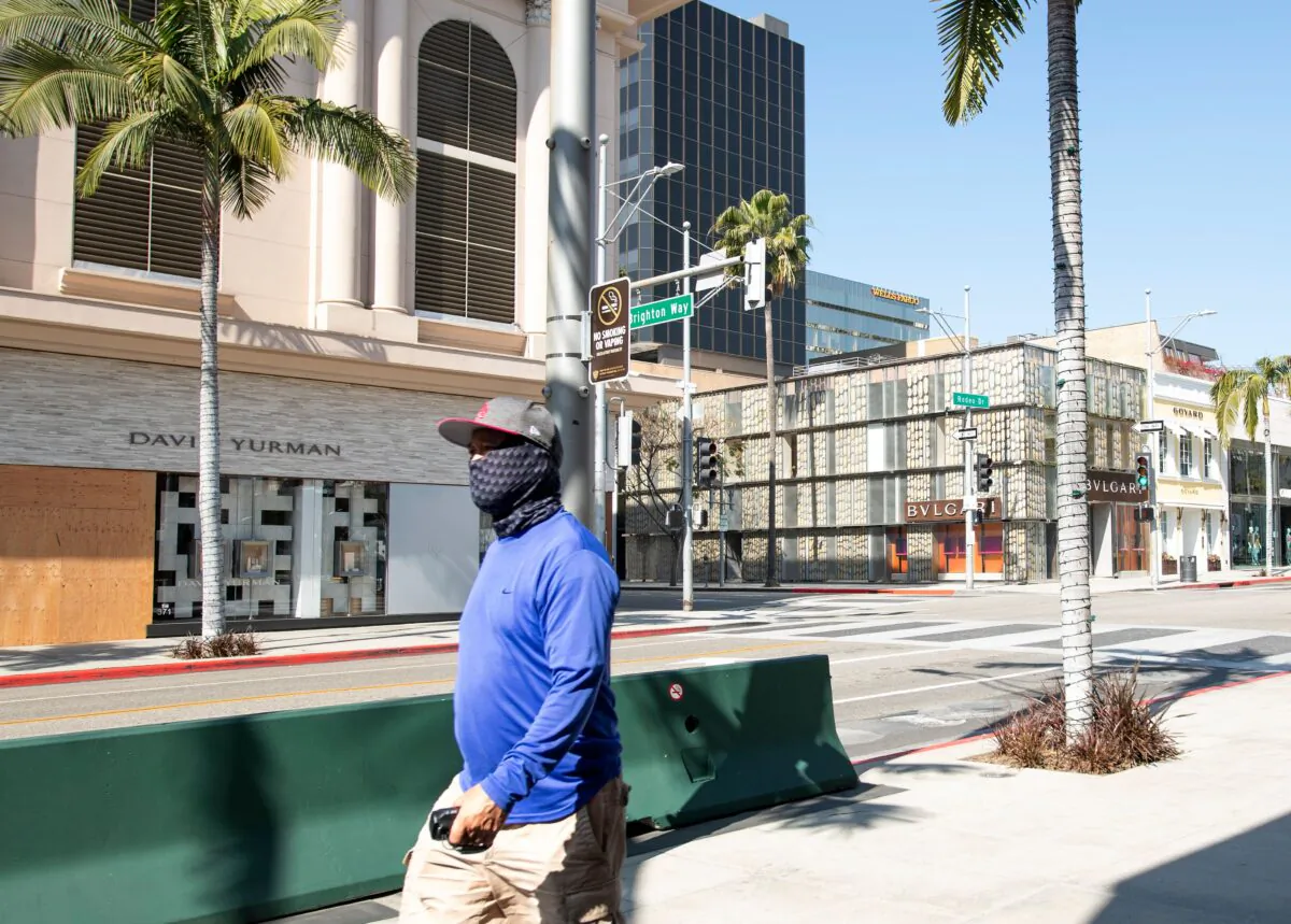 A person wearing a mask walks on Rodeo Drive in Beverly Hills, California, on April 1, 2020. (Valerie Macon/AFP via Getty Images)