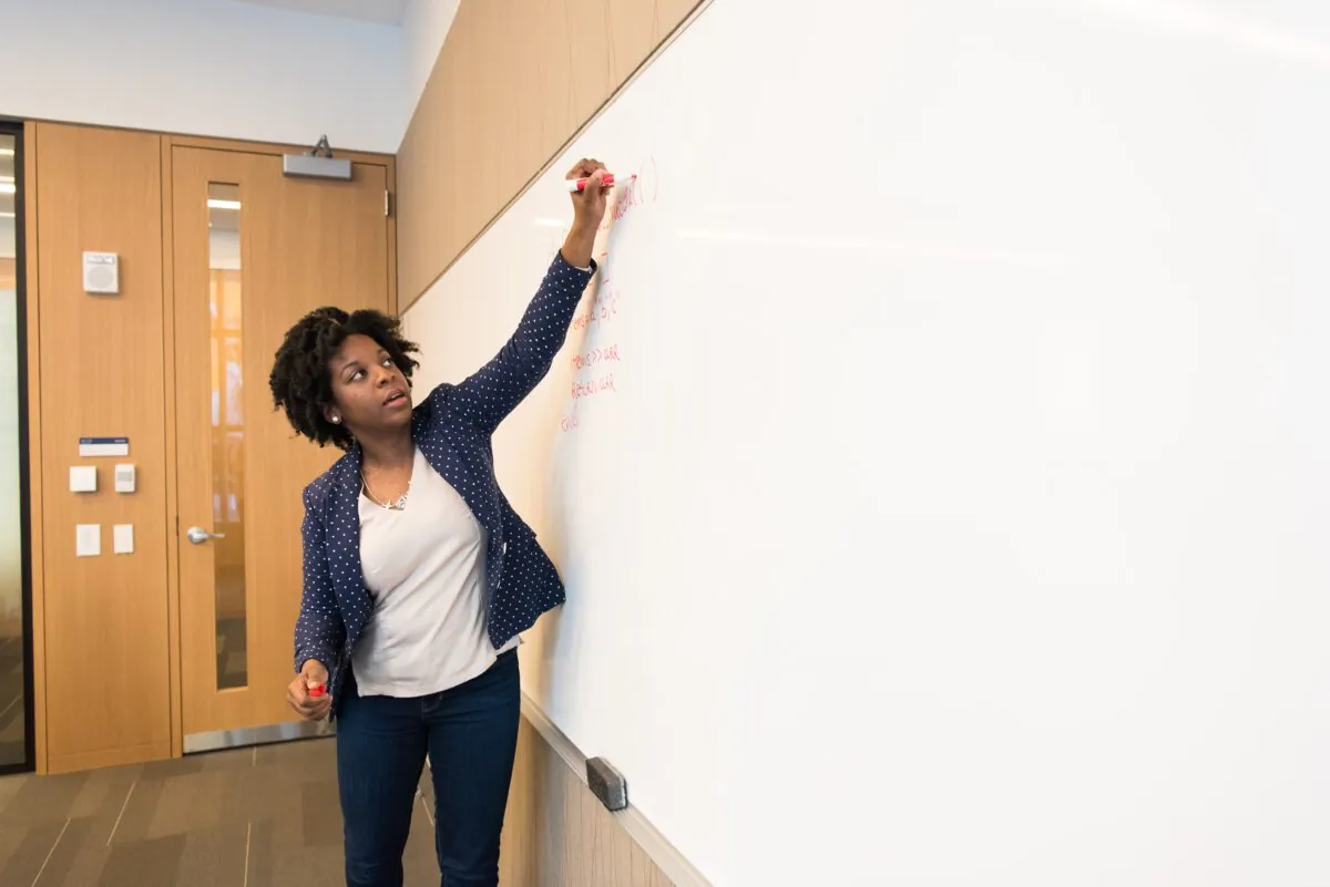 A file photo of a teacher writing on a white board. (Christina Morillo/Pexels)