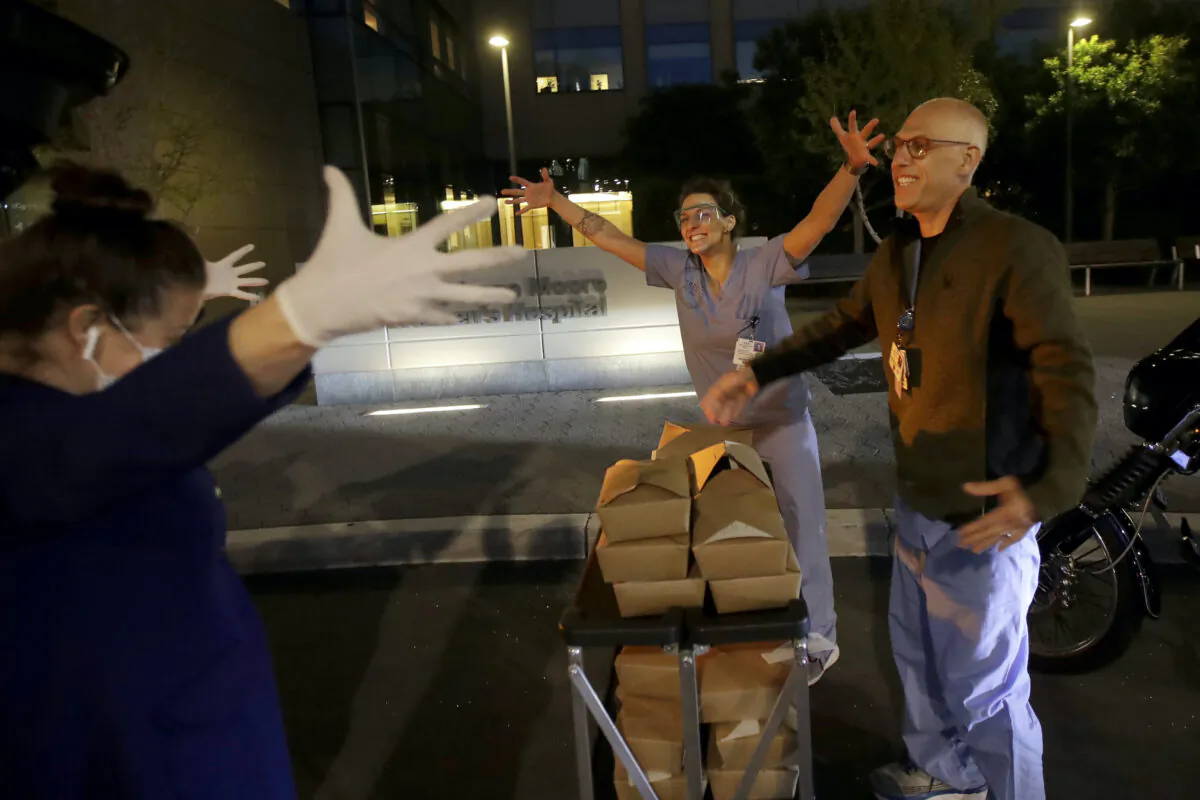 Nightbird Restaurant chef and owner Kim Alter (L) mimics giving a hug to hospital workers after delivering them dinner. (AP Photo/Jeff Chiu)