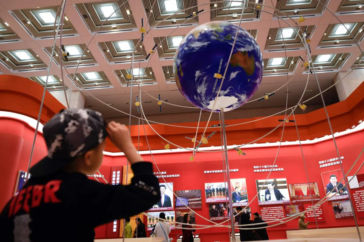 A boy looks at the BeiDou Navigation Satellite System at an exhibition marking the 40th anniversary of China's reform and opening up at the National Museum of China in Beijing, on Feb. 27, 2019. (Wang Zhao/AFP via Getty Images)