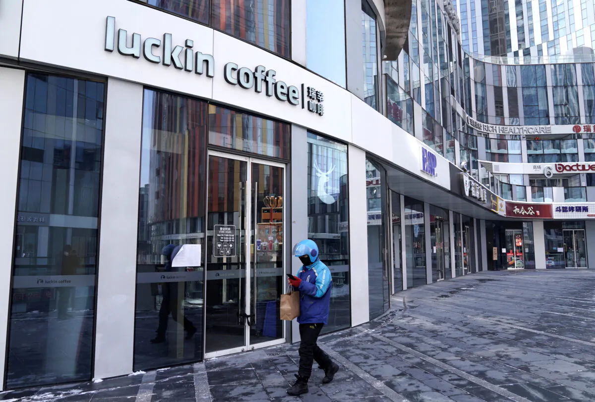 A deliveryman walks past a closed Luckin Coffee store in Beijing, China, on Feb. 7, 2020. (Jason Lee/Reuters)