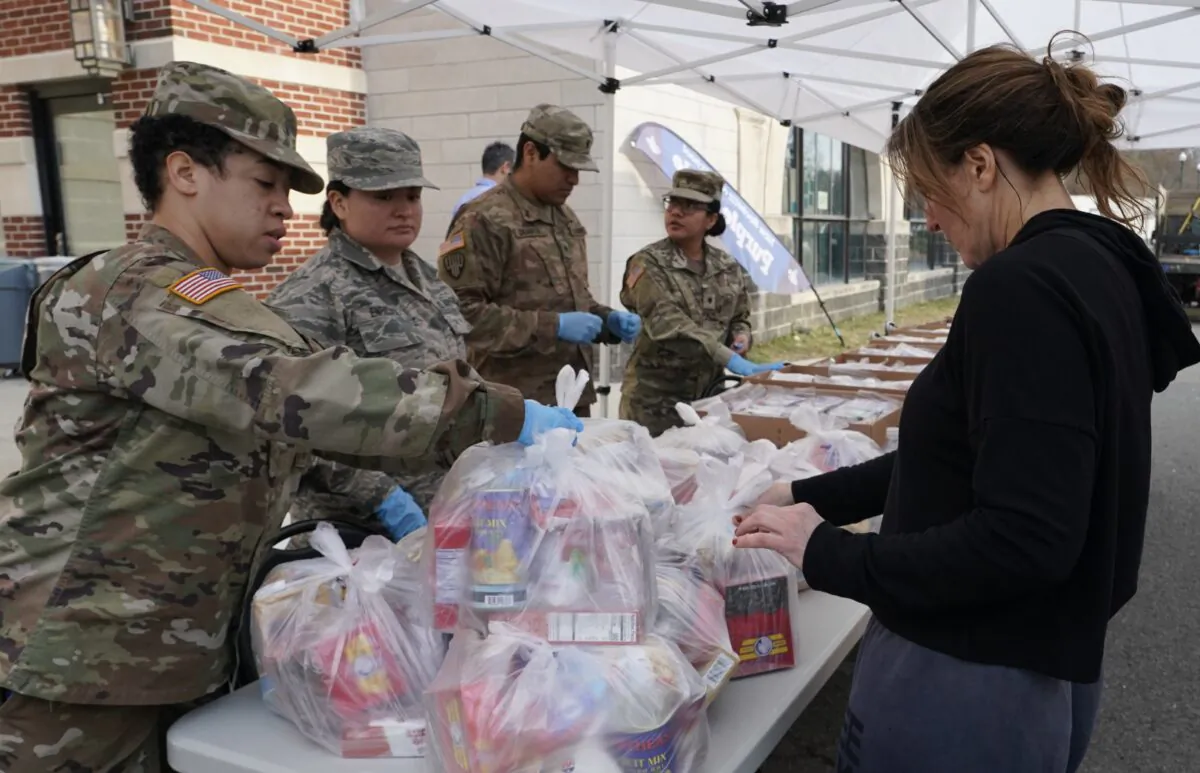 National Guard troops give food to residents of New Rochelle in Westchester County, N.Y., on March 12, 2020. (Timothy A. Clary/AFP via Getty Images)