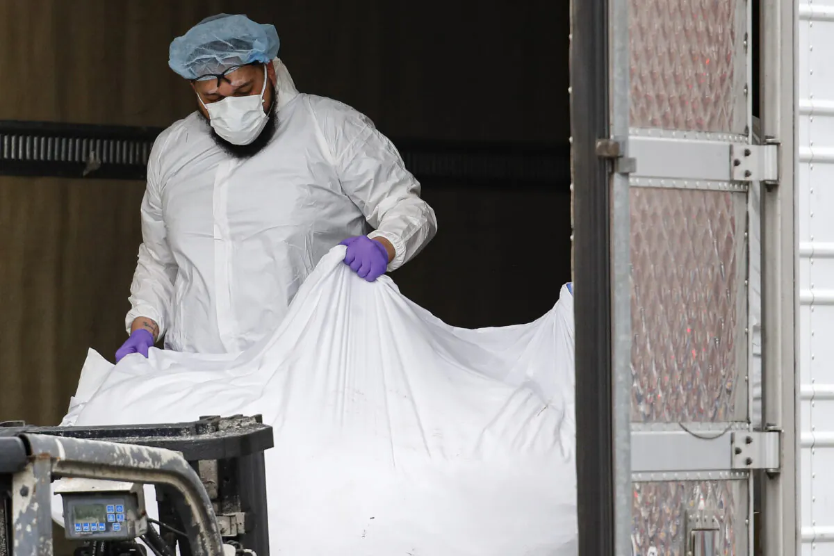 A body wrapped in plastic is loaded onto a refrigerated container truck used as a temporary morgue at Brooklyn Hospital Center in New York City, on March 31, 2020. (John Minchillo/AP Photo)