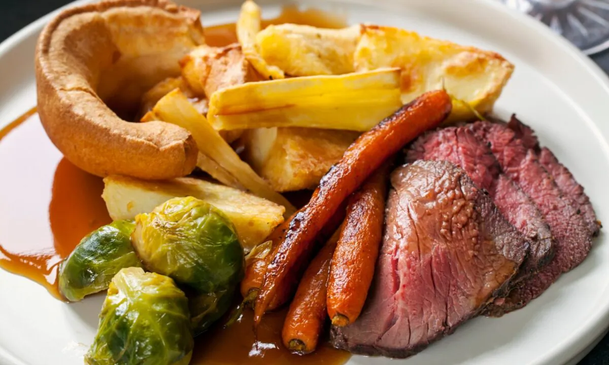 A typical Sunday roast consists of a nice cut of roast beef, potatoes and carrots, and Yorkshire puddings.