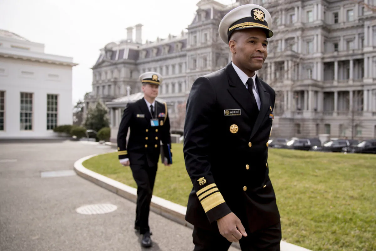 In this March 5, 2020, file photo, Surgeon General Jerome Adams, right, arrives to do an on camera interview outside the West Wing on the North Lawn of the White House in Washington. (Andrew Harnik/AP Photo)