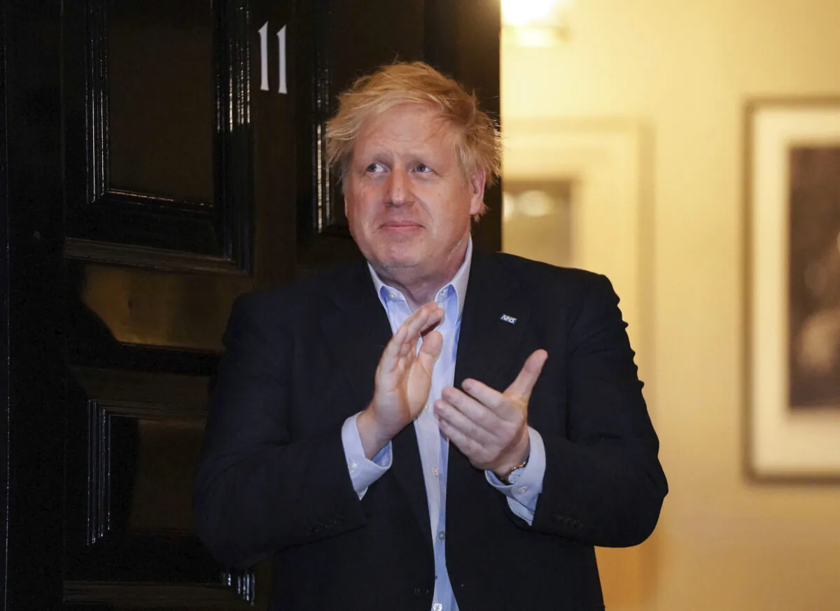 Britain's Prime Minister Boris Johnson claps outside 11 Downing Street to salute local heroes during the nationwide Clap for Carers NHS initiative to applaud workers fighting the CCP virus pandemic, in London, on April 2, 2020. (Pippa Fowles/10 Downing Street via AP)