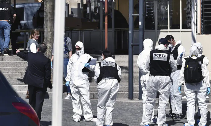 Police officers investigate after a man wielding a knife attacked residents venturing out to shop in the town under lockdown, in Romans-sur-Isere, southern France, on April 4, 2020. (AP Photo)