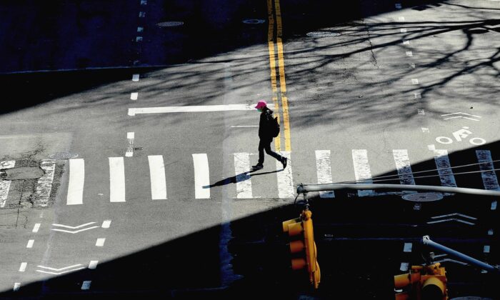 A person crosses the street in New York City on March 27, 2020. (Angela Weiss/AFP via Getty Images)