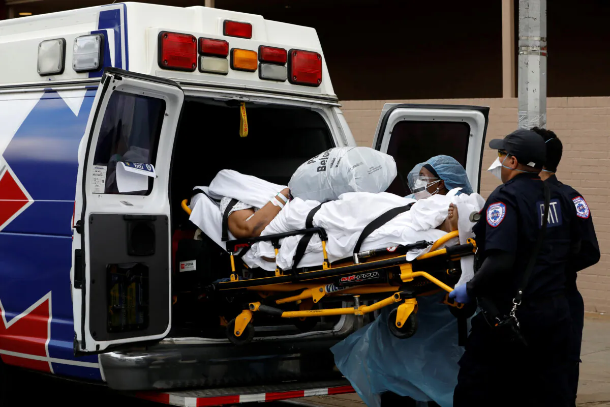 Healthcare workers load a person into an ambulance outside the Wyckoff Heights Medical Center during the outbreak of the CCP virus in the Brooklyn borough of New York City, New York, on April 4, 2020. (Andrew Kelly/Reuters)