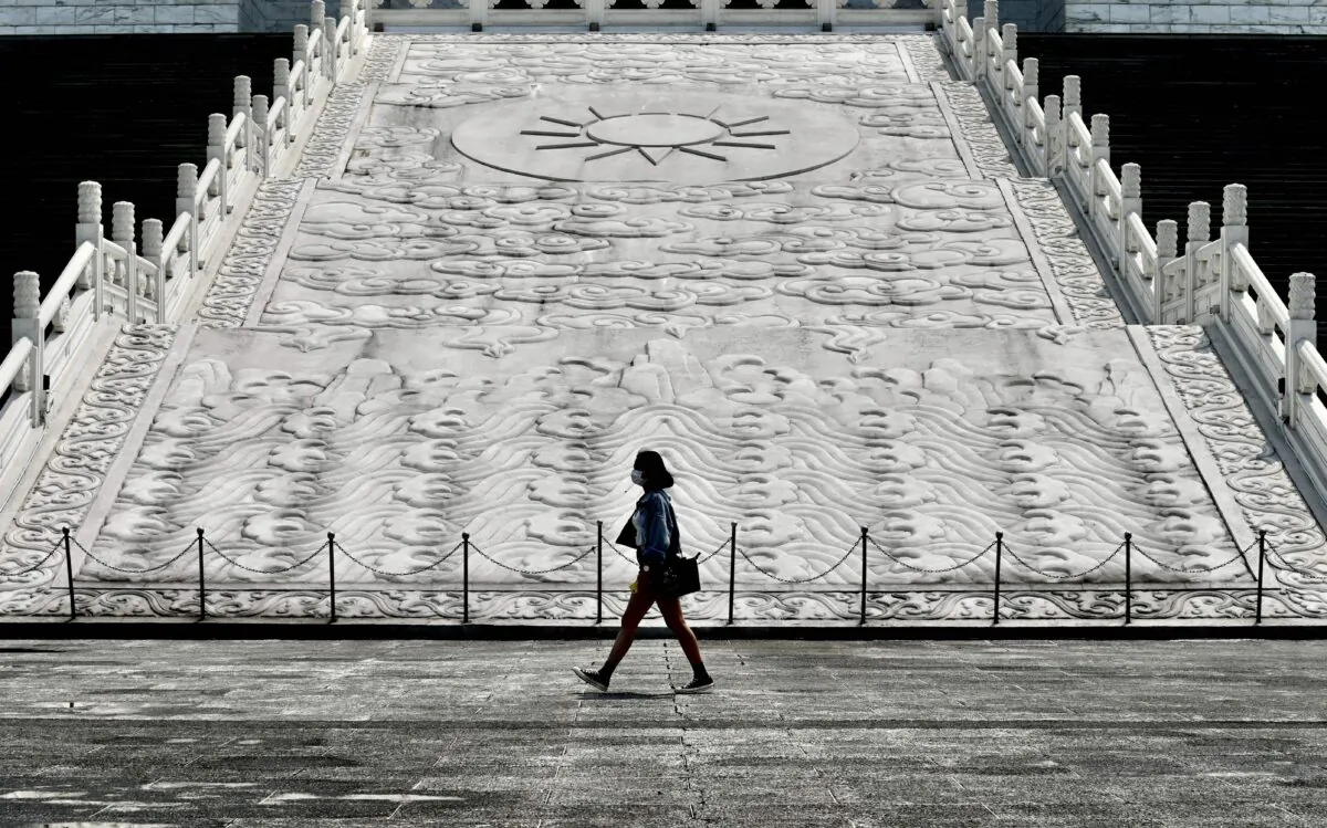 A woman wearing a face mask, amid concerns of the coronavirus, walks in front of Chiang Kai-shek Memorial Hall in Taipei, Taiwan, on March 31, 2020. (Sam Yeh/AFP via Getty Images)