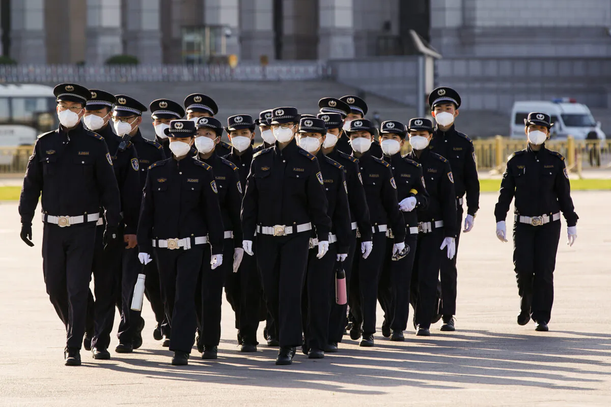 Chinese security personnel wearing protective masks march through Tiananmen Square in Beijing, China, on April 04, 2020. (Lintao Zhang/Getty Images)