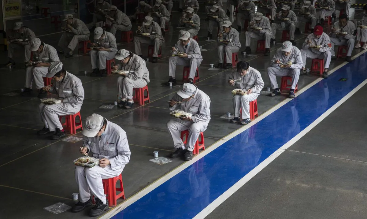 Employees eat their lunch while staying 2 meters away from each other at the Dongfeng Fengshen plant in Wuhan, Hubei Province, China, on March 24, 2020. (Getty Images)