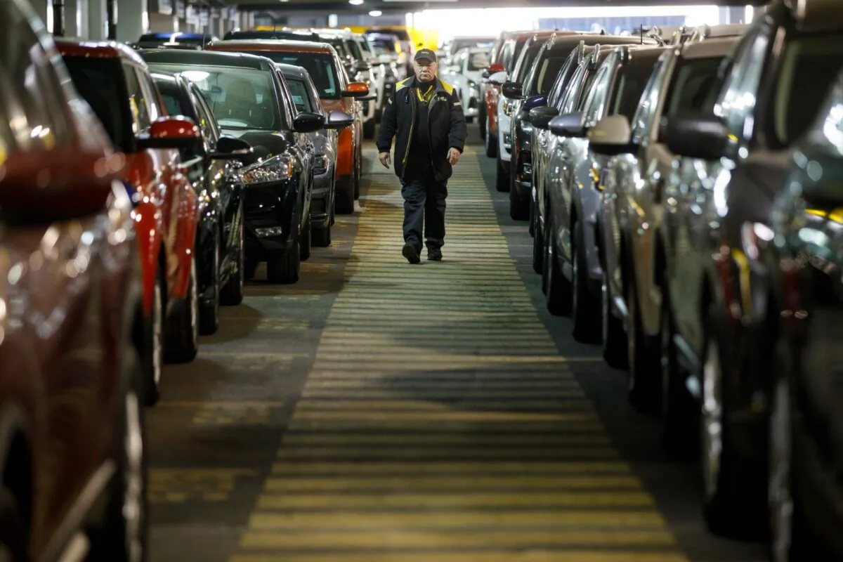 A Hertz Car Rental employee walks between rows of unused rental cars at Toronto Pearson International Airport in Toronto, Canada, on April 1, 2020. (Cole Burston/Getty Images)