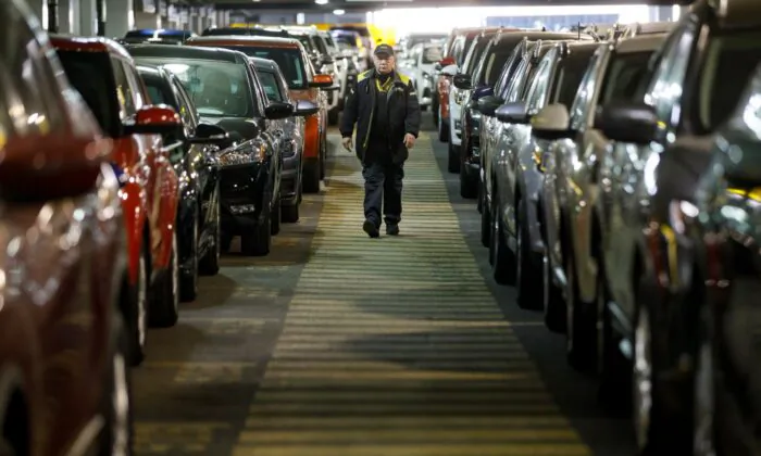 A Hertz Car Rental employee walks between rows of unused rental cars at Toronto Pearson International Airport in Toronto, Canada, on April 1, 2020. (Cole Burston/Getty Images)