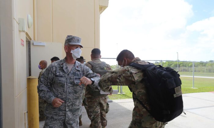 Maj. Dennis Kirkland, Guam National Guard state chaplain, greets Soldiers preparing to process through medical and customs checks at the GUNG readiness center after arriving on island April 5. (U.S. Army National Guard photo by JoAnna Delfin)