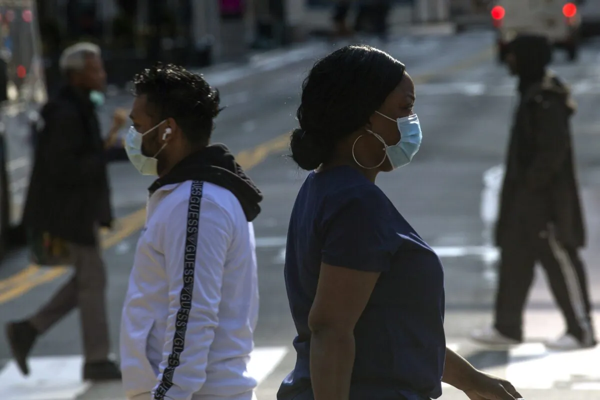 People wear masks as they walk along 34th Street in New York City on April 6, 2020. (Kena Betancur/Getty Images)