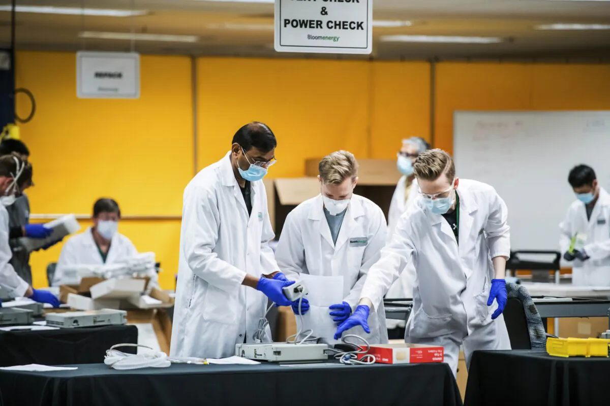 Medical staff work in a ventilator refurbishing assembly line at Bloom Energy in Sunnyvale, Calif., on March 28, 2020. (Beth LaBerge/KQED via AP, Pool)