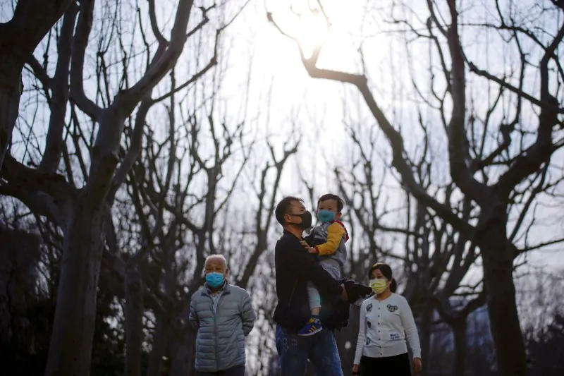 People wearing protective face masks in a park in Shanghai on March 18, 2020. (Aly Song/Reuters)
