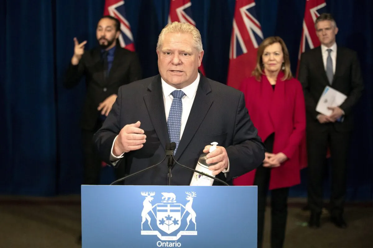 Ontario Premier Doug Ford holds a bottle of hand sanitizer during a press briefing at the Ontario Legislature in Toronto on March 28, 2020. (The Canadian Press/Chris Young)