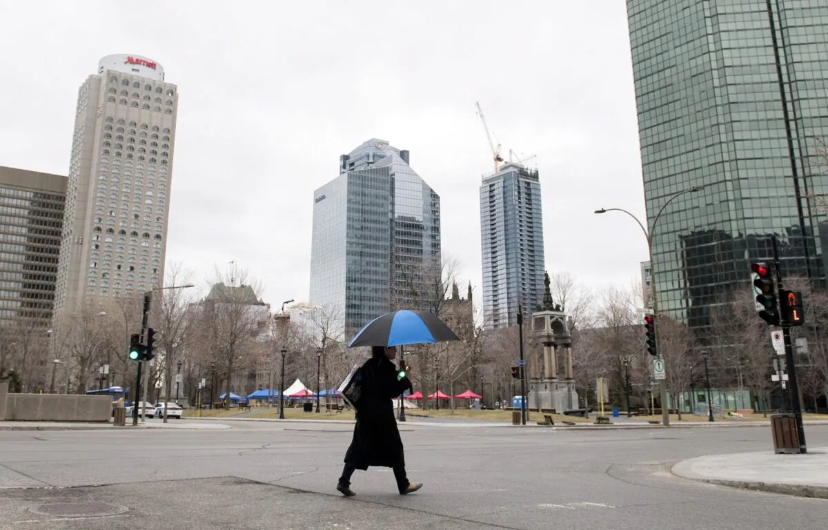 A woman crosses an empty street in downtown Montreal on April 5, 2020. (The Canadian Press/Graham Hughes)