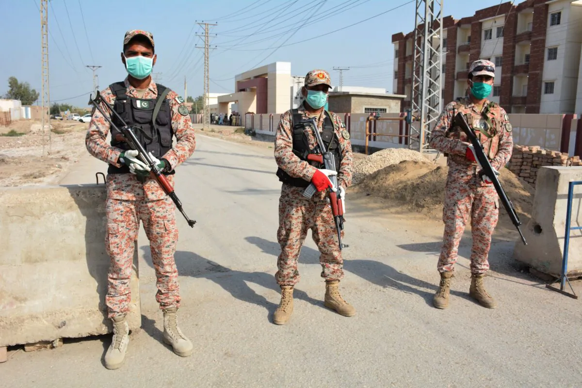 Soldiers in facemasks guard a road leading to a COVID-19 quarantine facility in Sukkur, Iran, on March 17, 2020. (Shahid Ali/AFP/Getty Images)