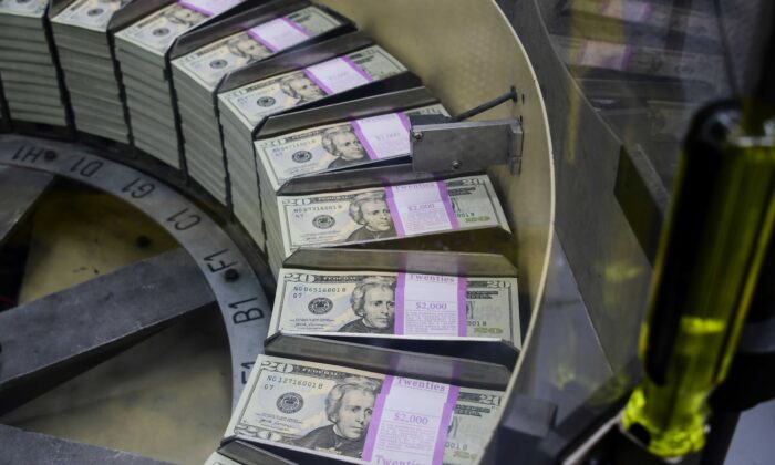 Packs of freshly printed 20 USD notes are processed for bundling and packaging at the U.S. Treasury's Bureau of Engraving and Printing in Washington on July 20, 2018. (Eva Hawbach/AFP via Getty Images)