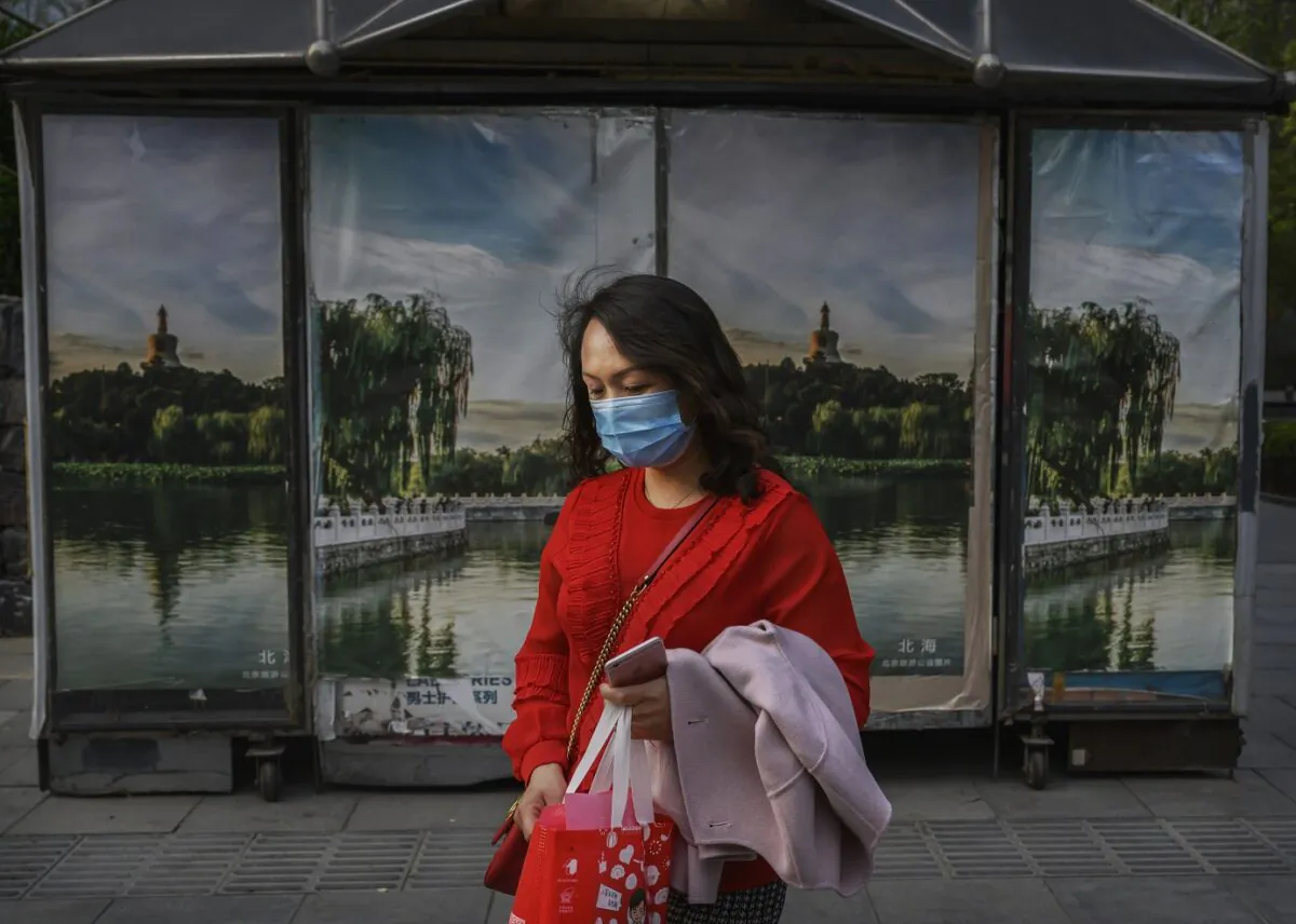 A Chinese woman wears a protective mask as she walks in the street in Beijing on April 7, 2020. (Kevin Frayer/Getty Images)