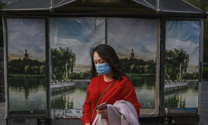 A Chinese woman wears a protective mask as she walks in the street in Beijing on April 7, 2020. (Kevin Frayer/Getty Images)