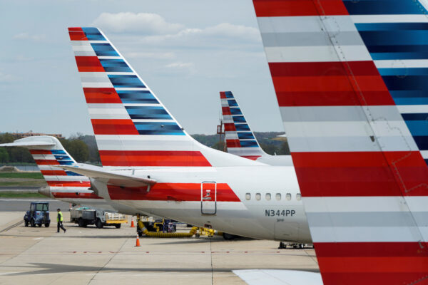 A member of a ground crew walks past American Airlines planes parked