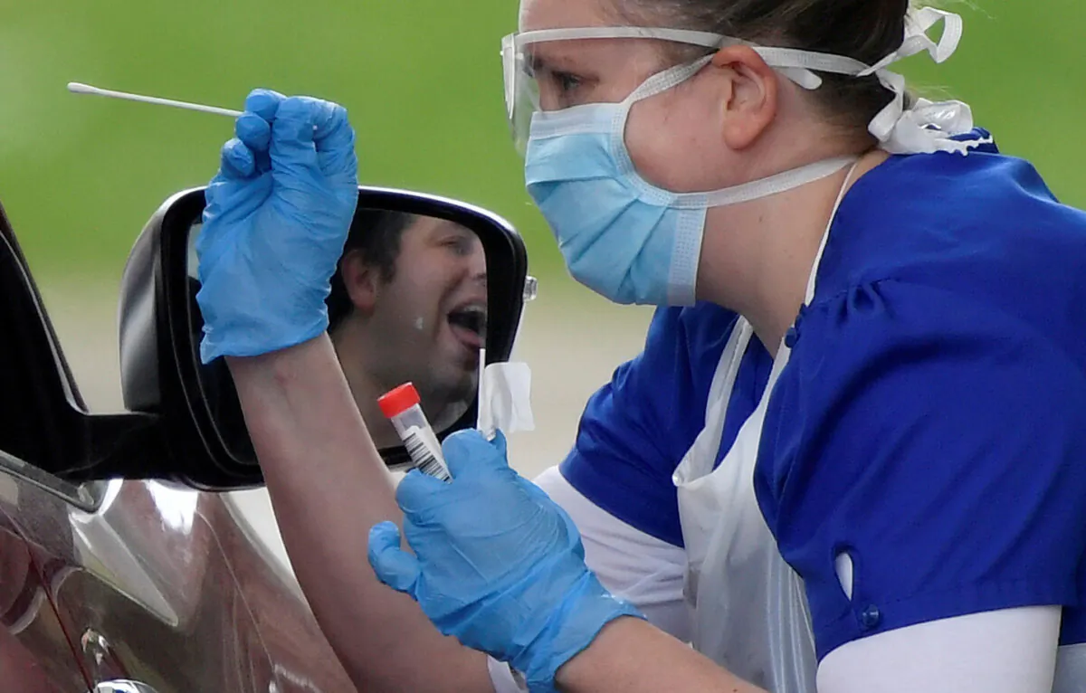 Medical staff testing people at a COVID-19 test centre in Chessington, UK, on April 2, 2020. (Toby Melville/Reuters)
