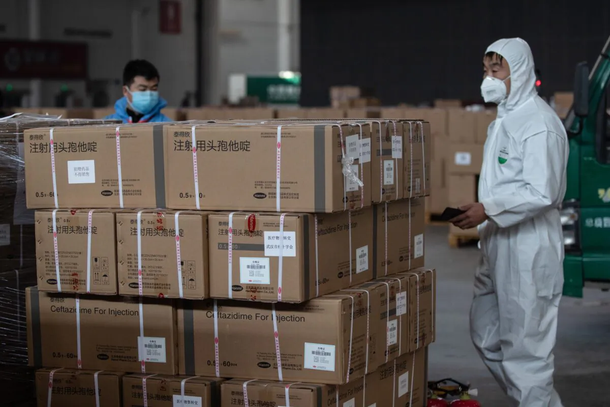Staff members and volunteers transfer medical supplies at a warehouse of an exhibition center which has been converted into a makeshift hospital in Wuhan, China, on Feb. 4, 2020. (STR/AFP via Getty Images)