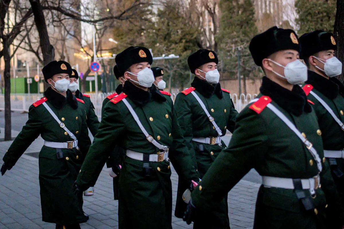 Paramilitary police officers wearing face masks as they walk along a street in Beijing on March 1, 2020. (Nicolas Asfouri/AFP via Getty Images)
