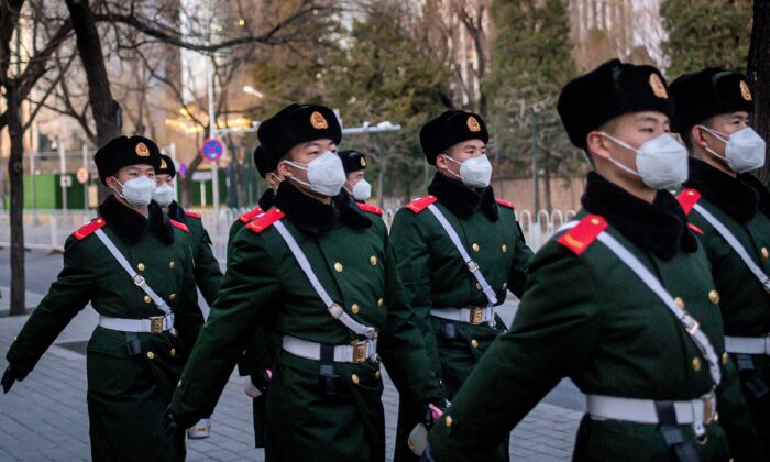 Paramilitary police officers wearing face masks as they walk along a street in Beijing on March 1, 2020. (Nicolas Asfouri/AFP via Getty Images)