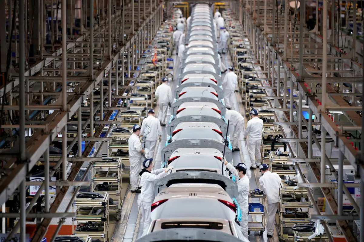 Employees work on a production line inside a Dongfeng Honda factory after lockdown measures in Wuhan, the capital of Hubei Province and China's epicenter of the novel coronavirus disease (COVID-19) outbreak, were further eased, on April 8, 2020. (Aly Song/Reuters)